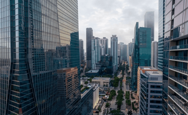 Glass office towers in Brickell, Miami, along a street lined with palm trees